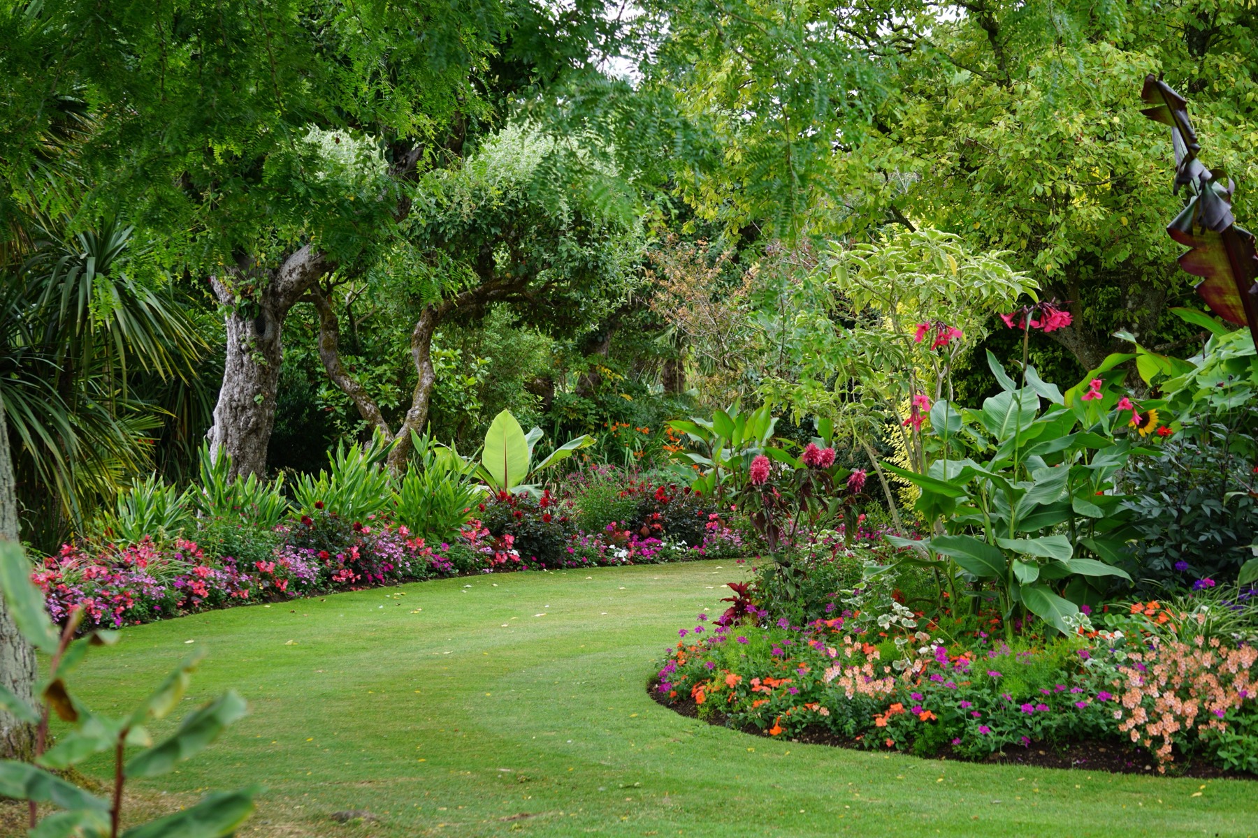 A well-kept garden with a neat lawn and colourful flower beds